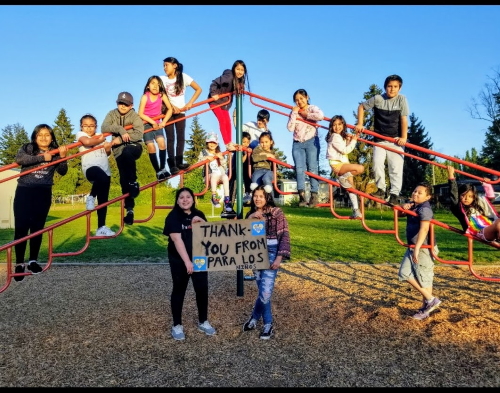Children in playfround holding a Thank You sign